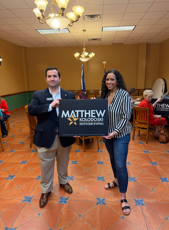 Matthew Kolodoski holding campaign sign at event
